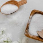 Detox Bath Epsom Salts in wooden bowl with wooden scoop on white background