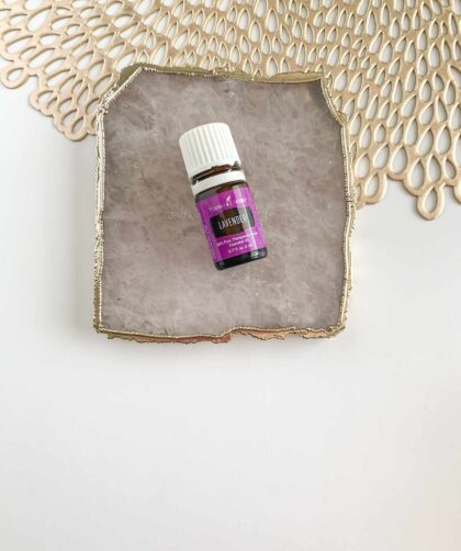 Lavender essential oil bottle on stone plate with gold accents