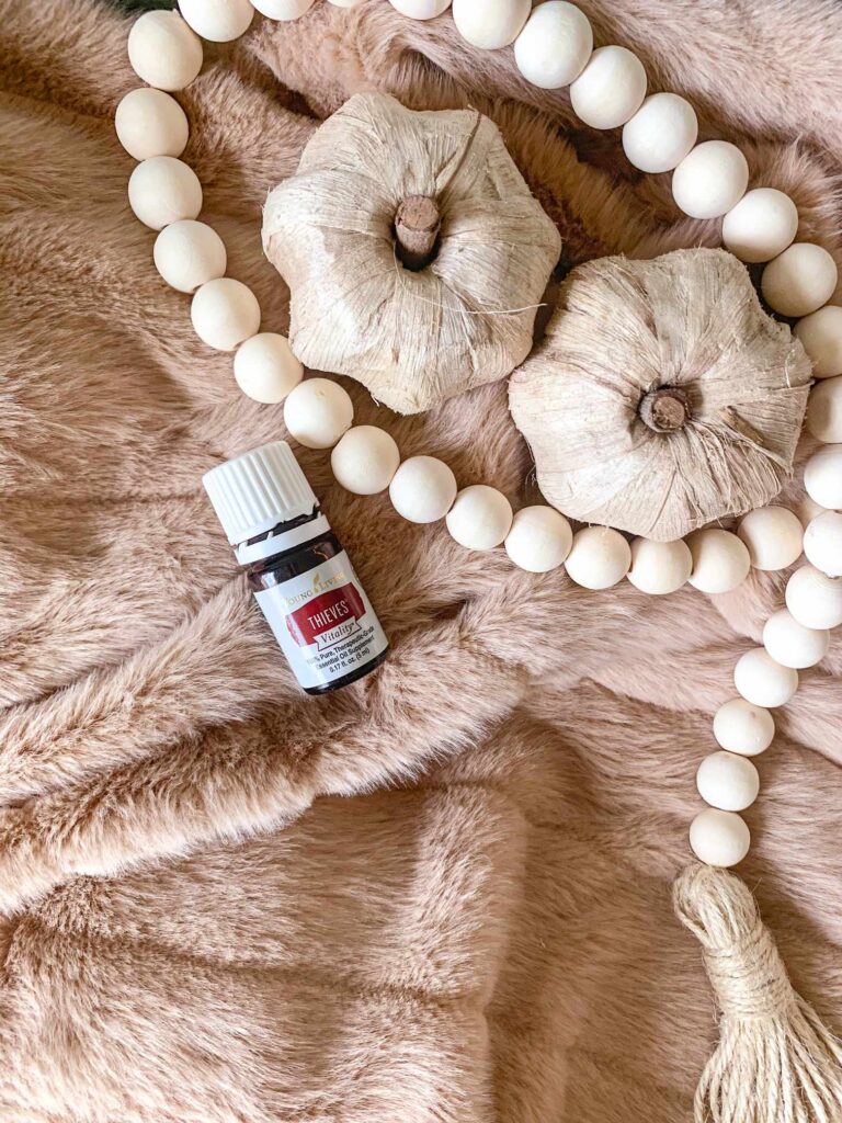 Thieves Vitality essential oil with white pumpkins on a fuzzy blanket