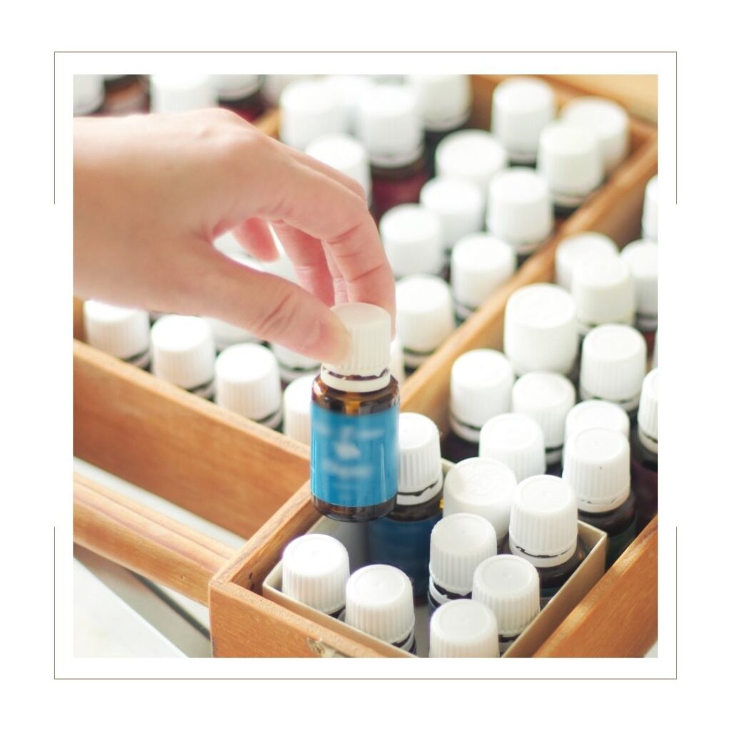 Stash of Essential Oil Bottles with White Lids Young Living in a wooden box