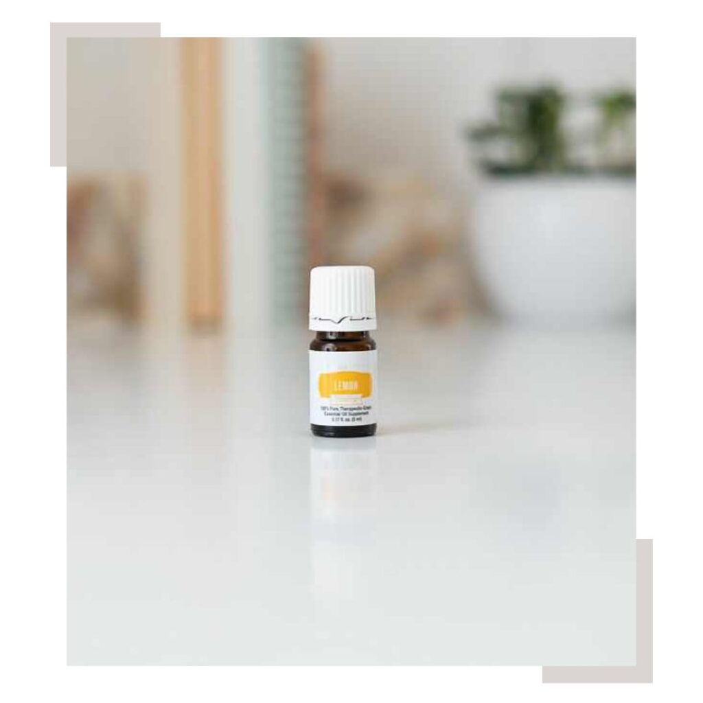 Lemon Vitality Essential Oil with books blurred out in the background on a countertop
