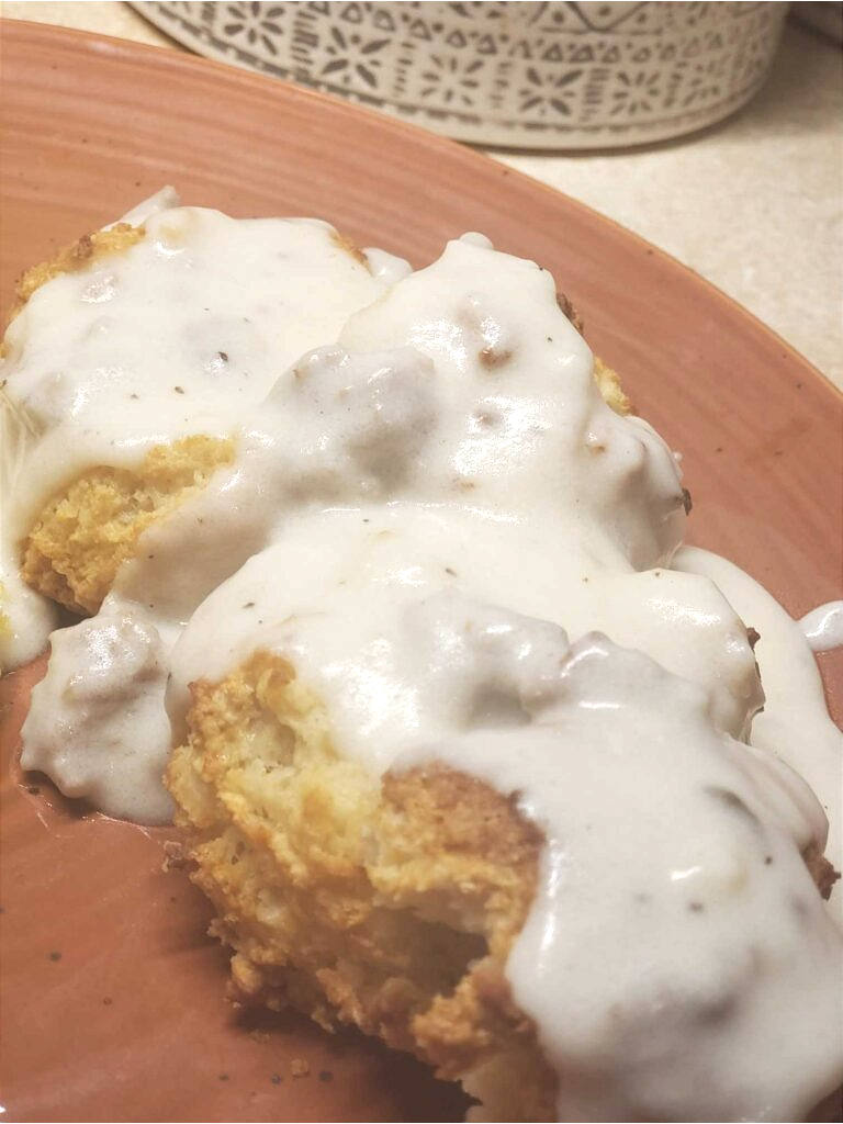 Biscuits and gravy on rust plate.