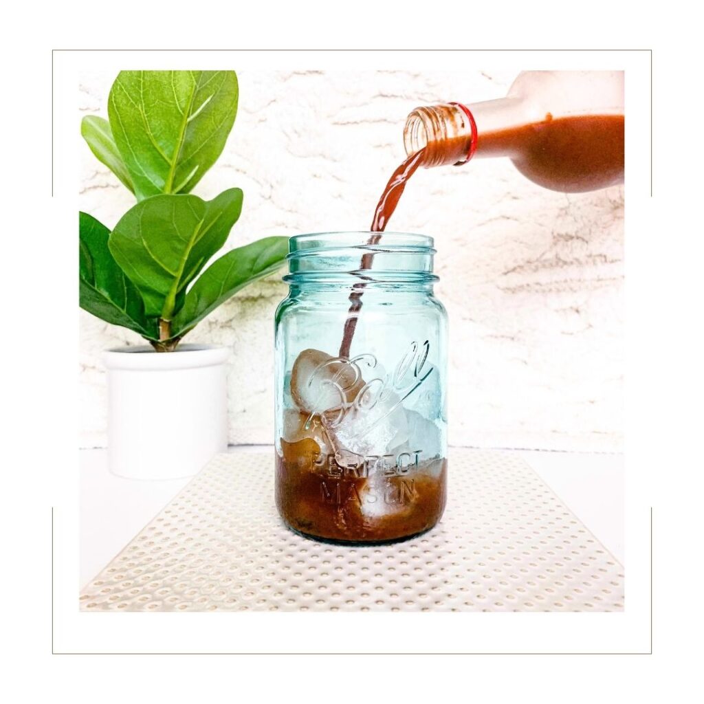 Ningxia Red pouring into a blue mason jar with ice.