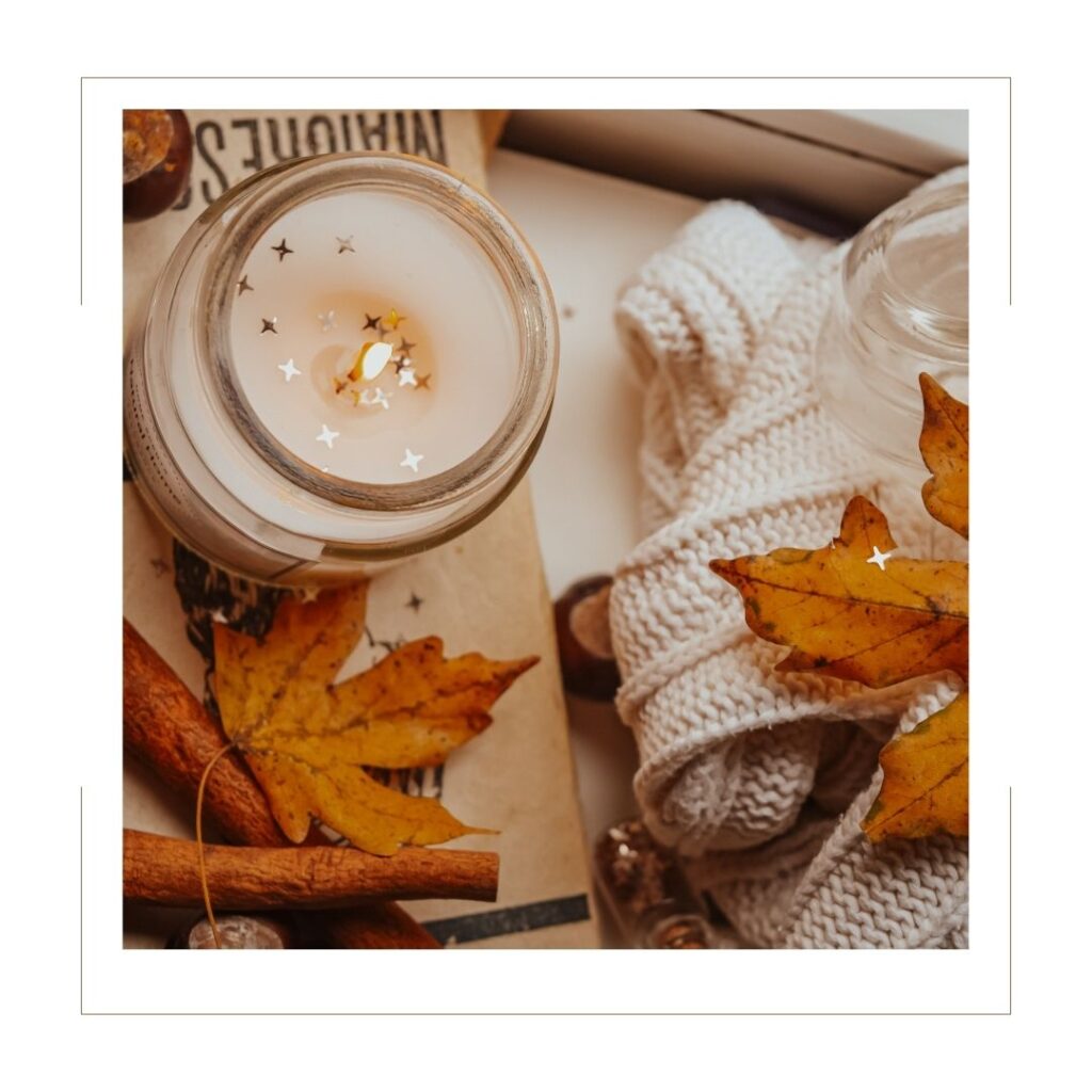 Fall candle with leaf decoration and a towel on a counter