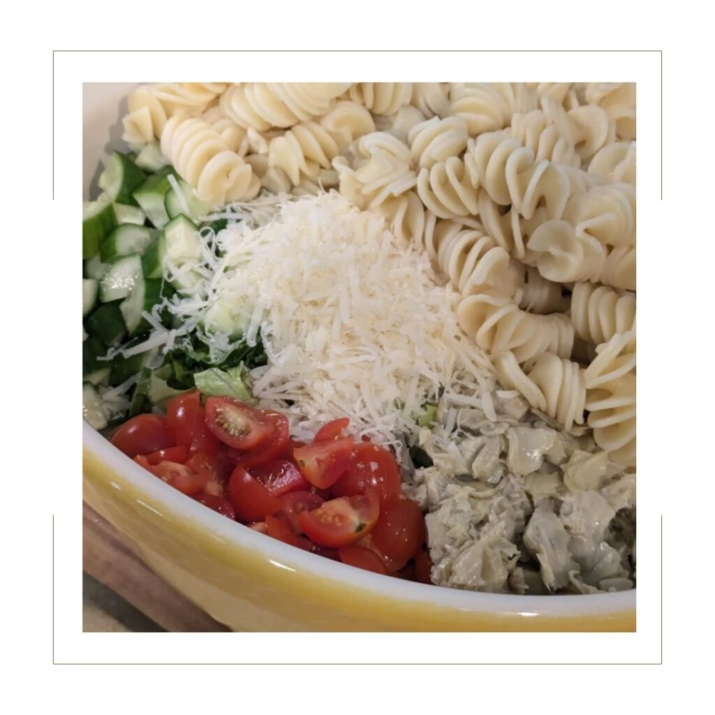 Caesar Salad Pasta Salad separated ingredients in a yellow bowl.