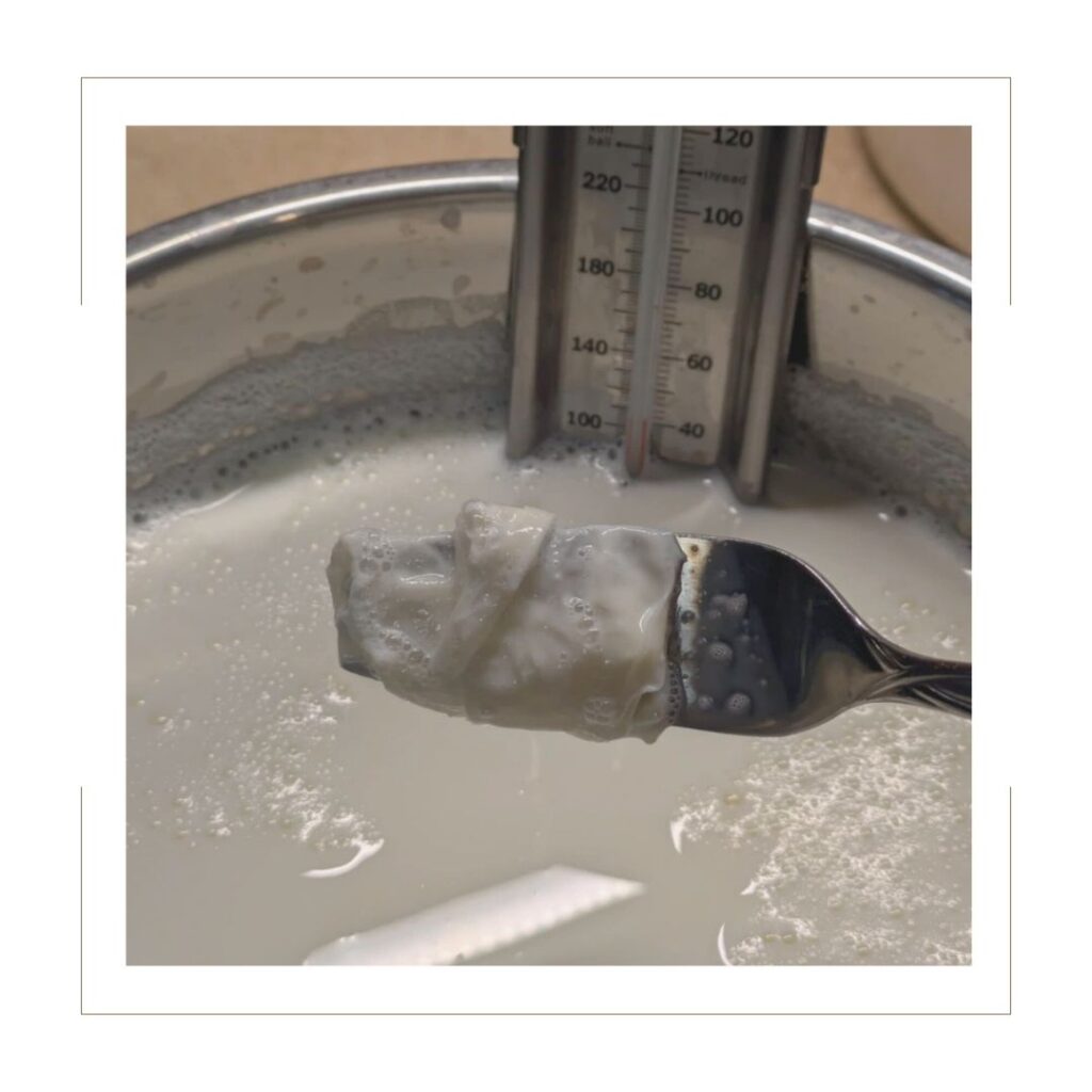 Homemade yogurt with skin over fork removing