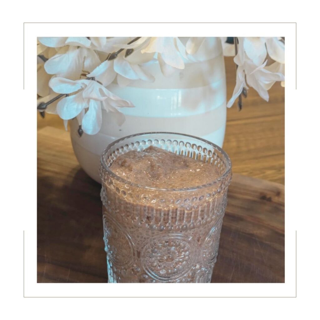 Chocolate Chia Pudding in a cute glass on a wooden board with white flowers