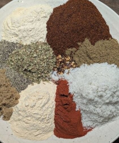 Overhead flat-lay of individual taco seasoning spices arranged on a white plate