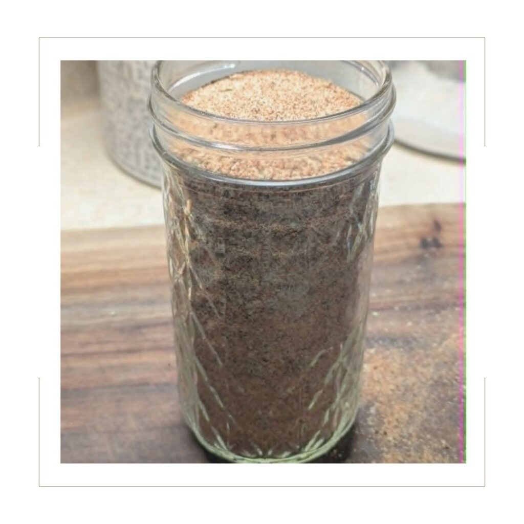 Homemade taco seasoning stored in a tall mason jar on the counter